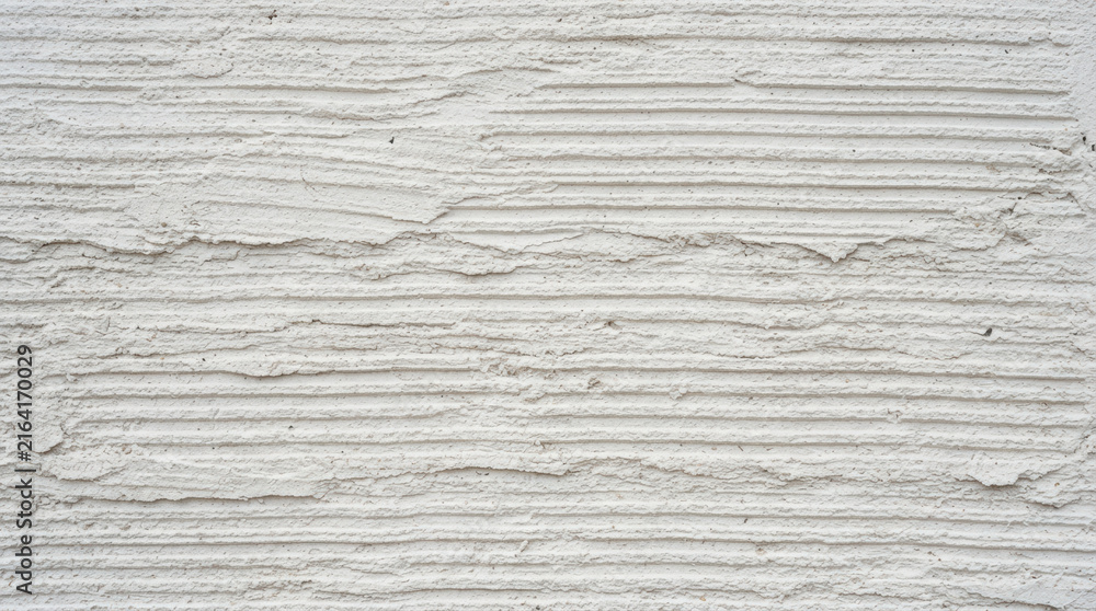 Fototapeta premium White stucco wall texture with horizontal ridges and grain