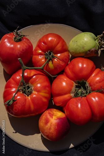 Ripe heirloom tomatoes with nectarine and green apple on plate