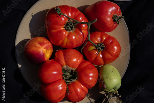 Ripe heirloom tomatoes with nectarine and green apple on plate
