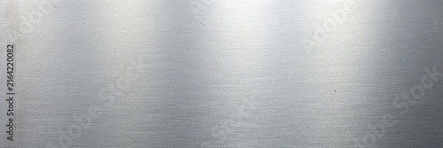 Brushed aluminum metal texture with light reflection, silver stainless steel background for industrial design, polished metallic surface with horizontal grain for modern tech backdrop