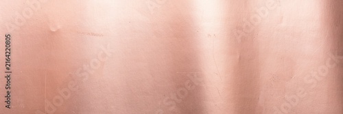 Rose gold metallic texture with soft light reflections, brushed copper foil background for luxury branding, elegant pink metal surface for cosmetic packaging and premium product design.
