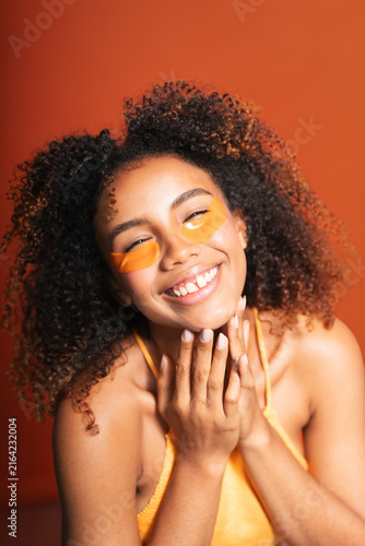 Fotografie Smiling woman using under eye patches for skincare routine