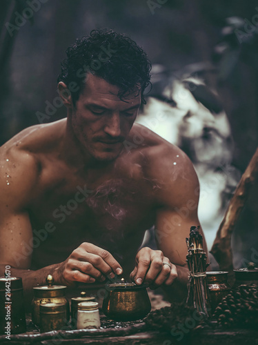 Man Preparing Ritual with Brass Vessels in Forest Light
