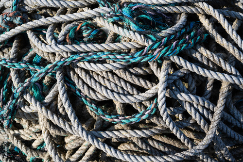Konstfotografi Old white rope mixed with blue cordage in a tangled weathered texture background
