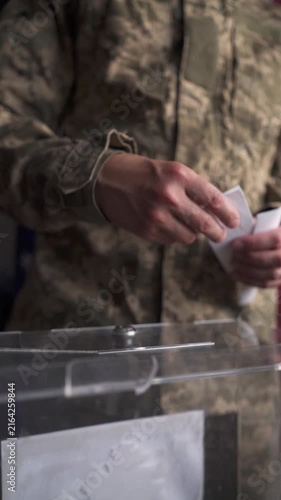 Vertical POV of soldier inserting ballot and walking away against blurred US flag