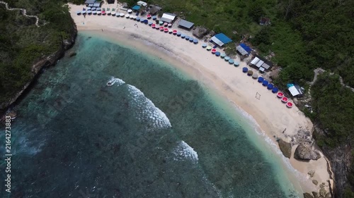 Aerial view of a beautiful tropical beach with turquoise ocean water, white sand and beach umbrellas