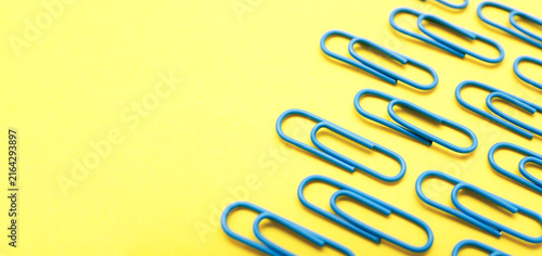 Blue Paper Clips on Yellow Background