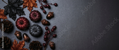 Halloween and autumn composition with pumpkins, acorns, pine cones and leaves on dark background