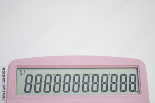 Top view of a digital calculator. Close up of a pink calculator screen displaying all eights on a twelve-digit LCD display, isolated with white background space above.