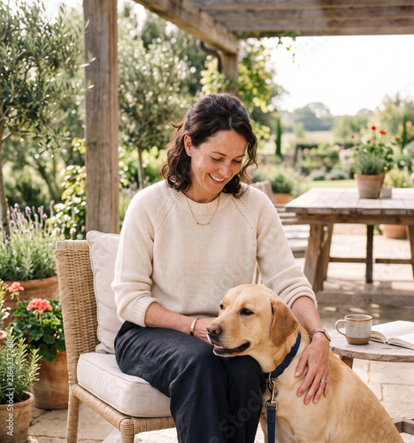Woman with dog relaxing after morning walk on terrace