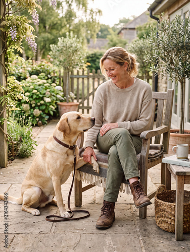 Woman with golden dog relaxing in the morning on terrace