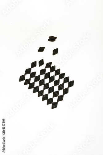 Black salty liquorice candies form a geometric pattern on white