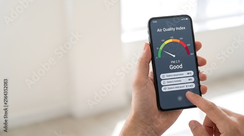 Person checks air quality index on smartphone app showing good pm2.5 levels