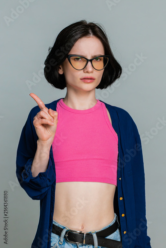 Foto Woman firmly shakes head and raises palm, clearly indicating disagreement, refusal or rejection with serious facial expression