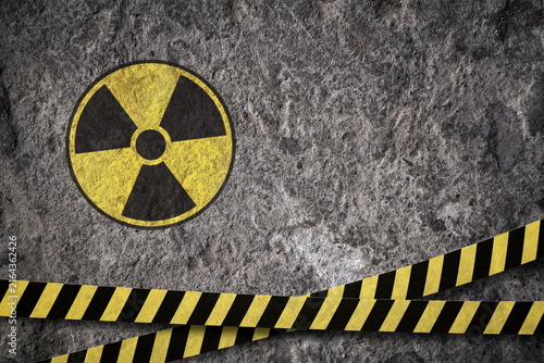 radiation hazard sign and black yellow tape om grunge background