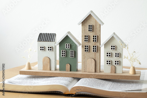 Miniature houses on top of holy bible book. Copy space. Christian concept of faith in God Jesus Christ, family, fellowship and community.