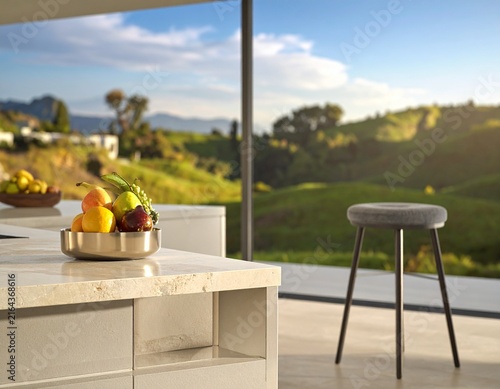 Bright modern home interior with kitchen island and scenic outdoor landscape