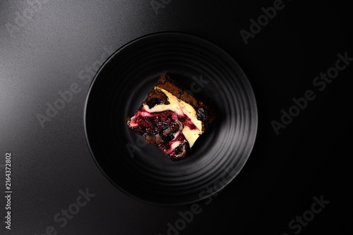 Close-up of delicious homemade cranberry cream cheese brownies on a dark background