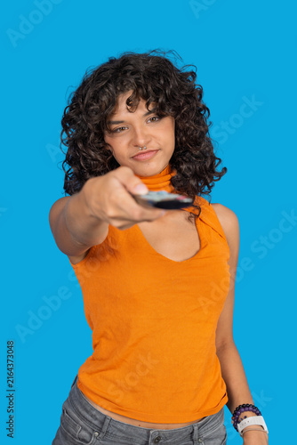 Fotografie Young woman holding remote control choosing entertainment