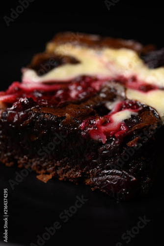 Close-up of delicious homemade cranberry cream cheese brownies on a dark background