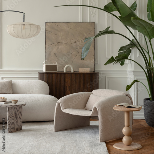 Modern minimalist living room interior with cozy white bouclé armchair, elegant sofa, large tropical plant, abstract art piece and wooden furniture