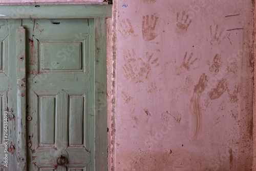 Konstfotografi Handprints on ancient wall next to a green wooden door in Yazd, Iran