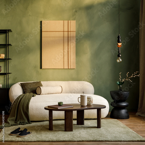 Modern minimalist living room interior with cozy white sofa, wooden coffee table, abstract art piece, olive green wall and warm decor accents