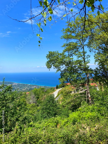Fotografie Unsurpassed panorama from the thickets of the mountain forest of the lush blue of the Aegean Sea on the horizon with coastal settlements on the slopes of the mountain hills