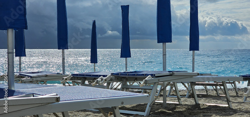 Fotografie Deckchairs and umbrellas at a beach resort during a summer holiday