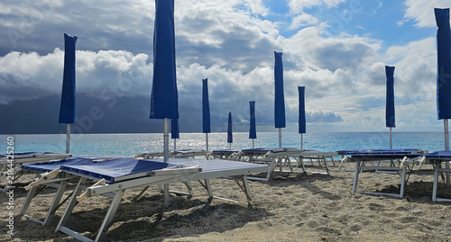Foto Deckchairs and umbrellas at a beach resort during a summer holiday