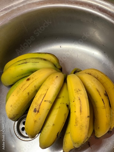 Fresh Ripe Yellow Bananas Resting in Stainless Steel Kitchen Sink