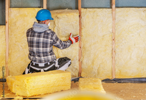 Worker installs insulation in a building during a renovation project