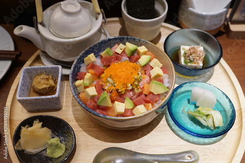Konstfotografi Japanese diced sashimi rice bowl set served with ochazuke dashi teapot, tofu, wasabi and side dishes on wooden tray