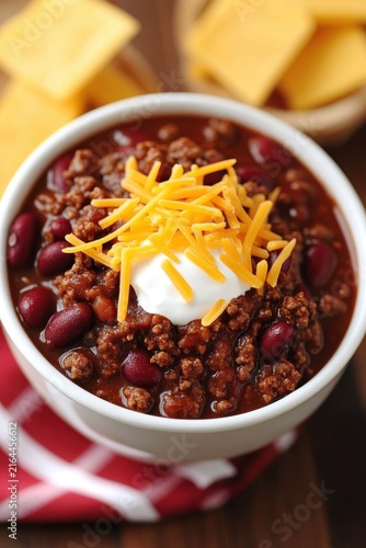 Delicious Bowl of Chili Topped with Cheese and Sour Cream Garnish