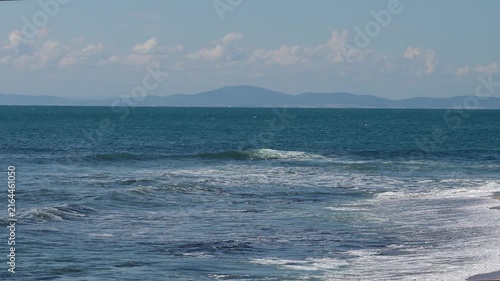 ocean waves swelling, cresting, and crashing into turbulent white foam, 