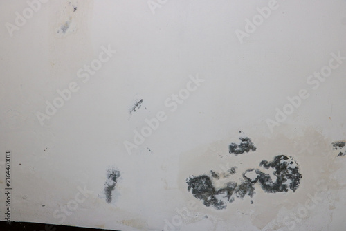 Damaged wall surface showcasing decayed industrial texture with chipped layers of white paint