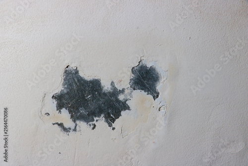 Damaged wall surface showcasing decayed industrial texture with chipped layers of white paint