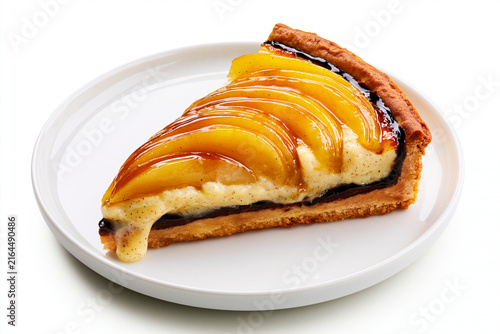 Part de tarte poire chocolat sur fond blanc, sur assiette blanche. Pâte brisée, couche de ganache, poires pochées nappées et migaine façon crème pâtissière