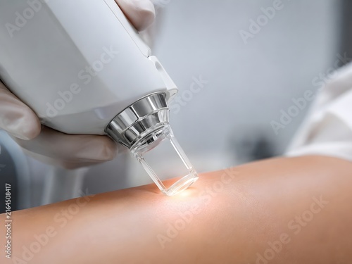 Laser treatment machine handpiece close up on smooth skin surface