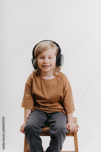 portrait of cute 4-5 year old boy with headphones on his head on white background