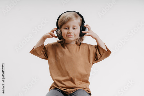 portrait of cute 4-5 year old boy with headphones on his head on white background