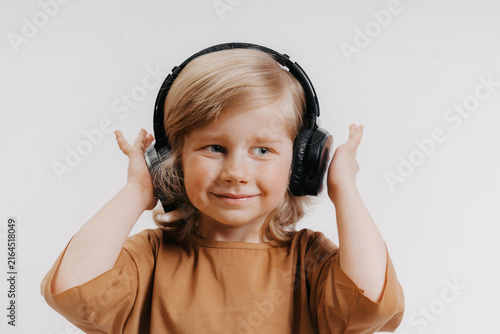 portrait of cute 4-5 year old boy with headphones on his head on white background