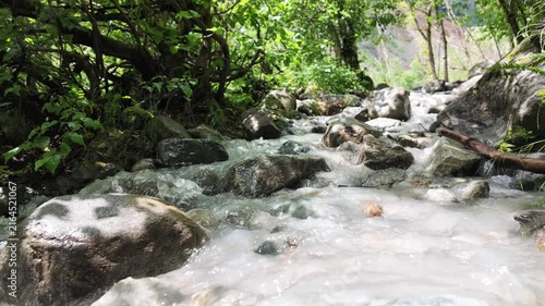 Glacial meltwater stream rushing over wet rocks below Shkhara glacier in Mestia, Svaneti region of Georgia, pristine mountain wilderness and wild nature conservation concepts