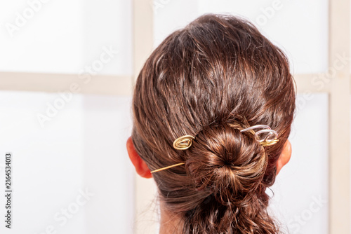 Obraz na płótnie Beautiful Female Model Styling Her Long Light Brown Hair with Silver Pins