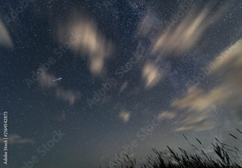 Perseid meteor and Milky Way through drifting clouds in Latvia