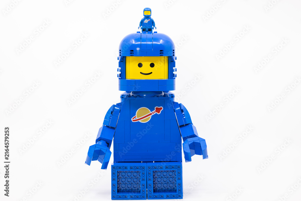 Naklejka premium Hong Kong, June 8, 2026: A giant classic spaceman strides forward, carrying a tiny companion perched atop his helmet.