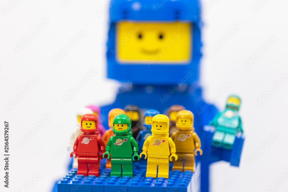 Naklejka premium Hong Kong, June 8, 2026: Colorful classic spacemen gather on a blue baseplate before a giant smiling LEGO head.