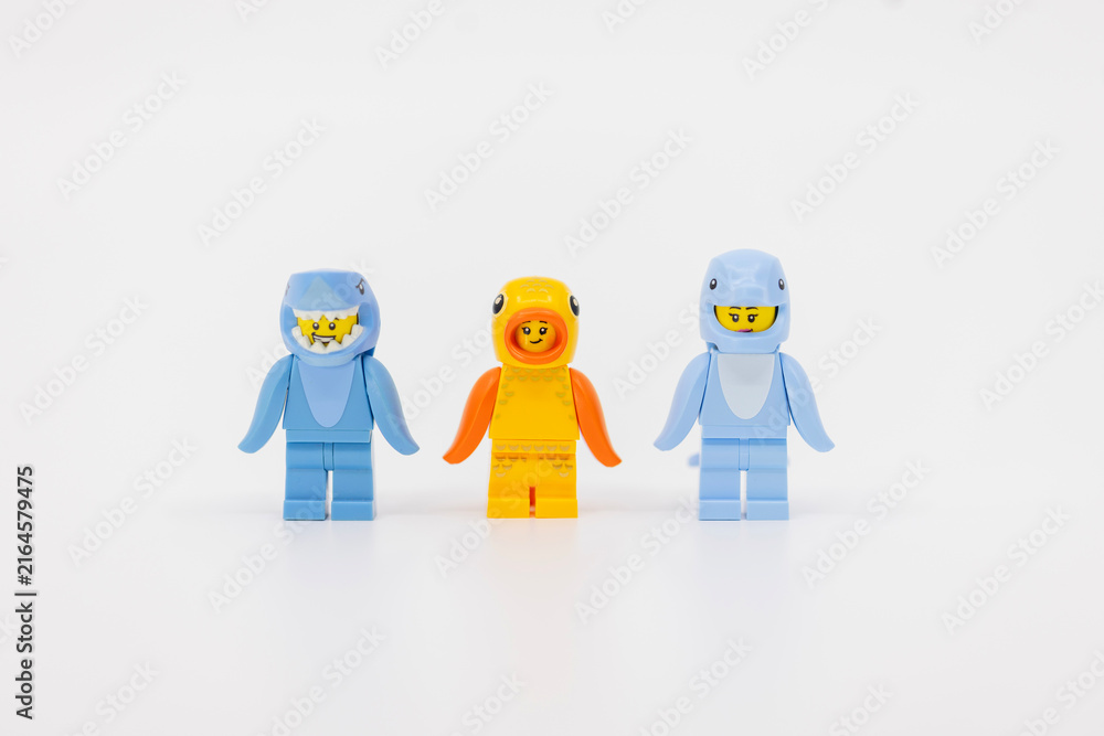 Fototapeta premium Hong Kong, June 8, 2026: Three toy minifigures wearing sea animal costumes feature a shark, fish, and dolphin.