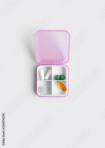 Pink Plastic Pill Organizer with Medication Isolated