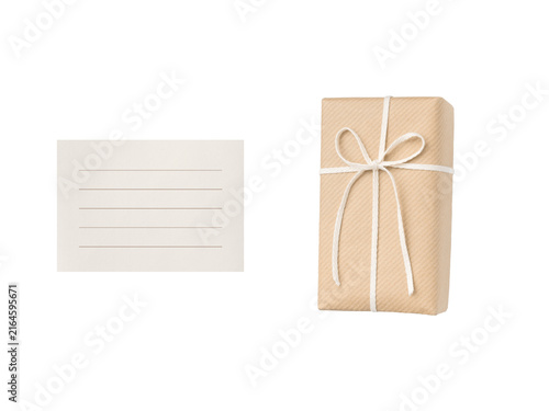 Overhead view of a kraft paper gift box with a white ribbon and a pale beige ruled card.